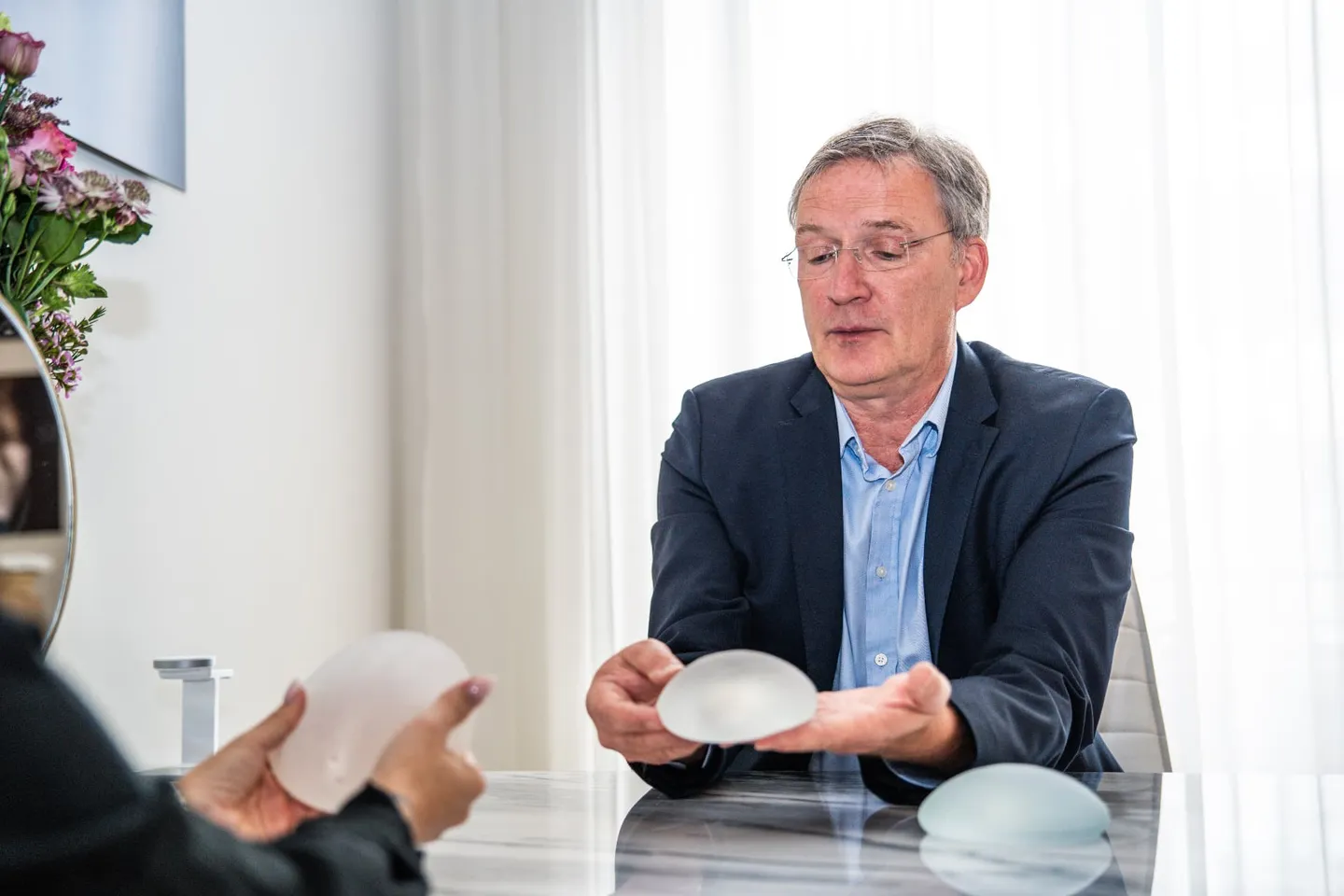 Dr. med. Michael W. Payne erläutert ein Brustimplantat im Beratungsgespräch